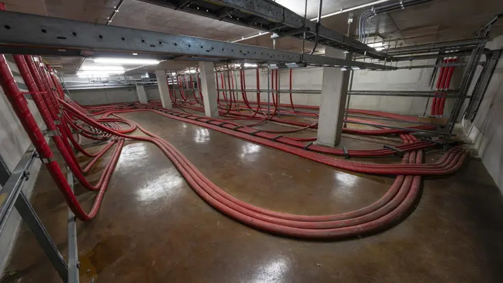 Zware rode elektriciteitskabels lopen door het Kracht Warmte Station.