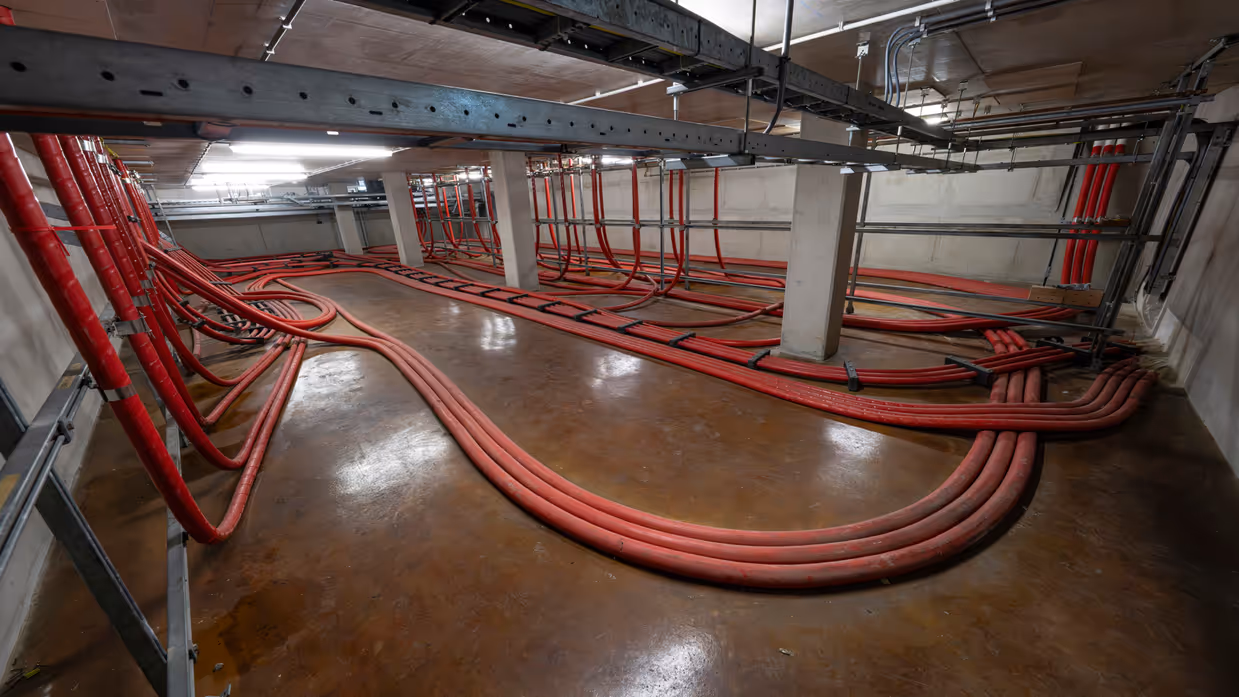Zware rode elektriciteitskabels lopen door het Kracht Warmte Station.
