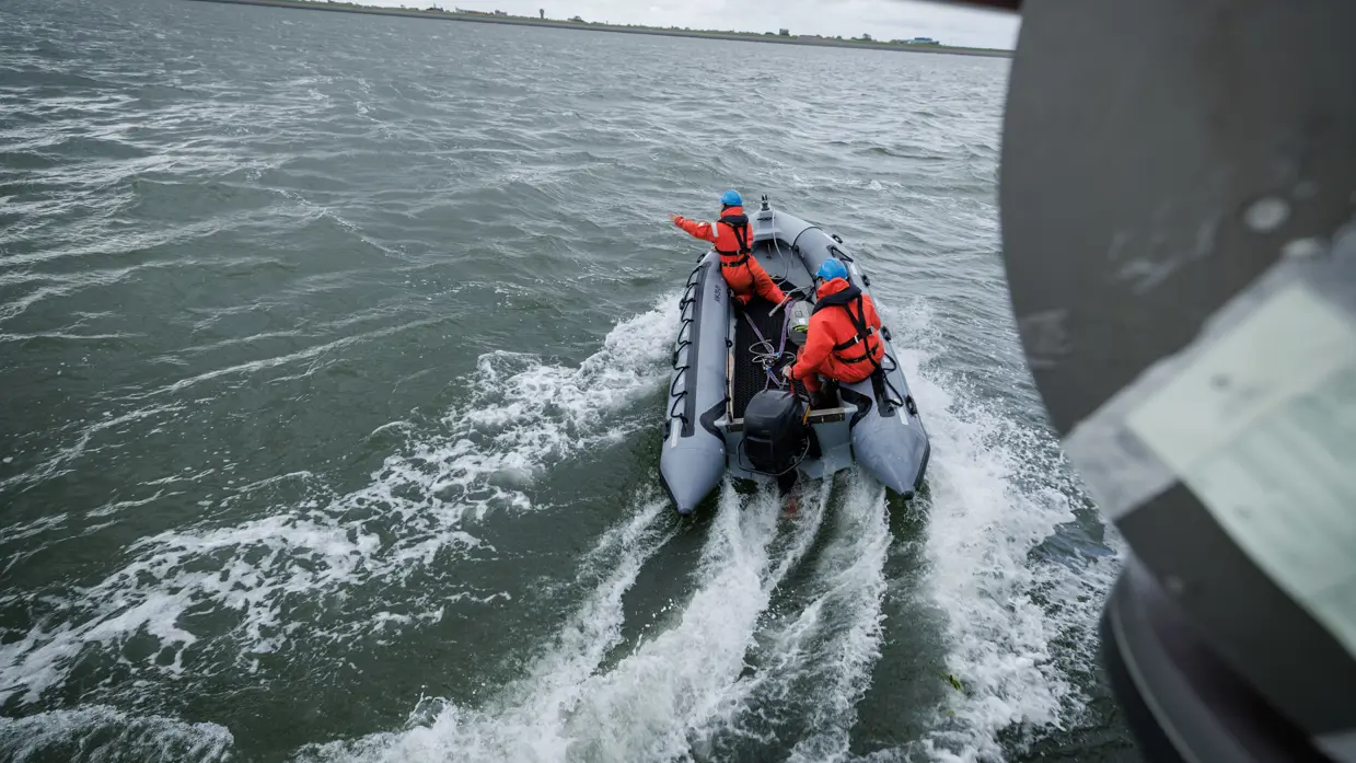 2 militairen met rubberboot varen weg richting de zogenaamde drenkeling