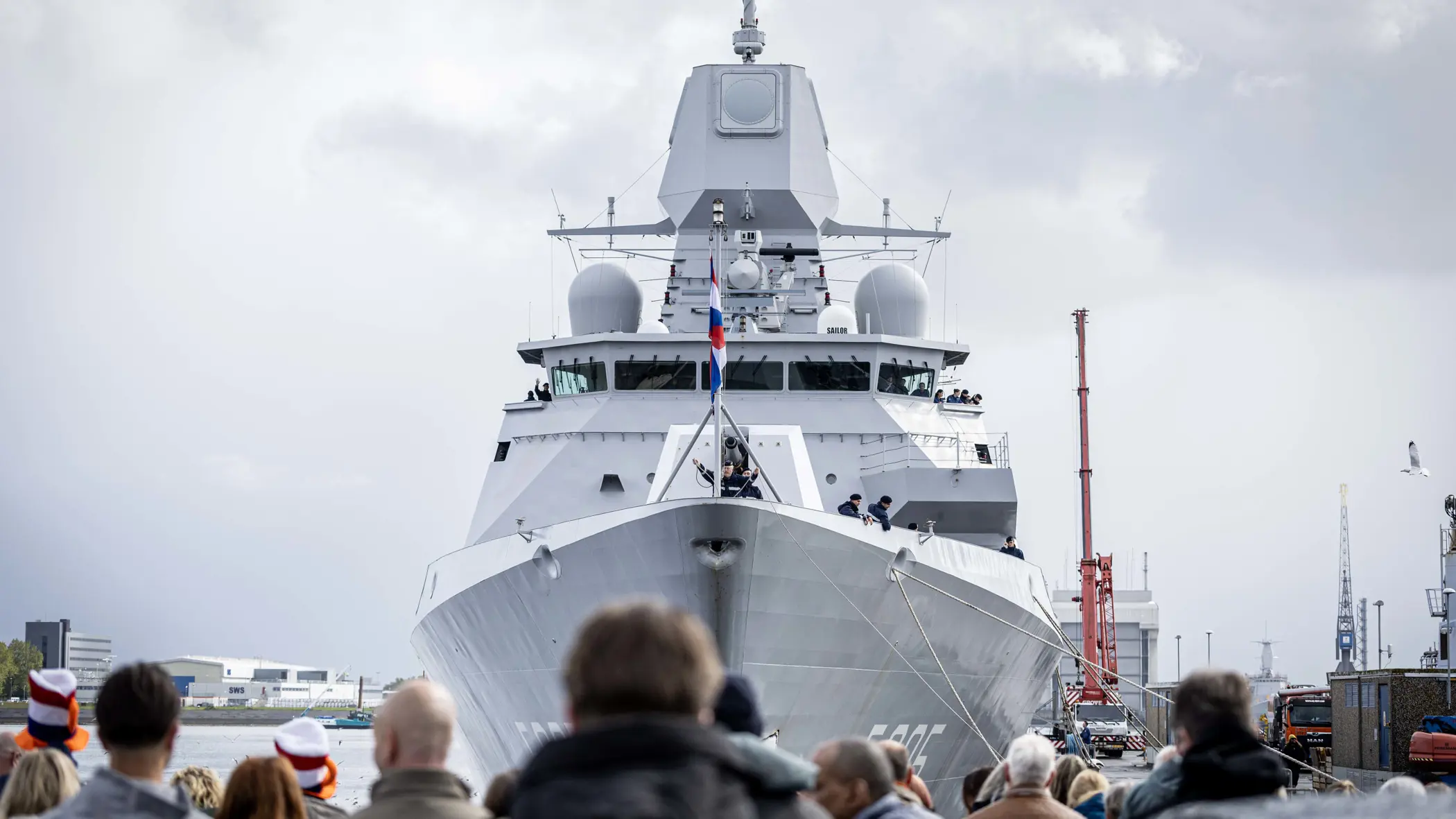 Zr.Ms. Evertsen is net afgemeerd; op de voorgrond vrienden en familie van de opvarenden.