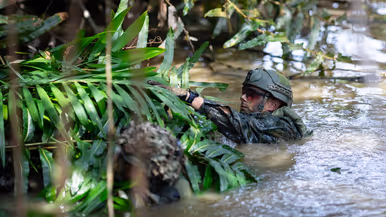 Mariniers houden een drijfpakket in de rivier vast   Marinier legt takken op het drijfpakket 