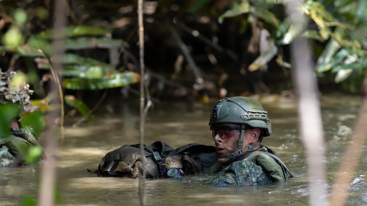 Mariniers vervoeren een drijfpakket via het water en een marinier in het water.