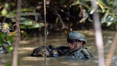 Mariniers vervoeren een drijfpakket via het water en een marinier in het water.