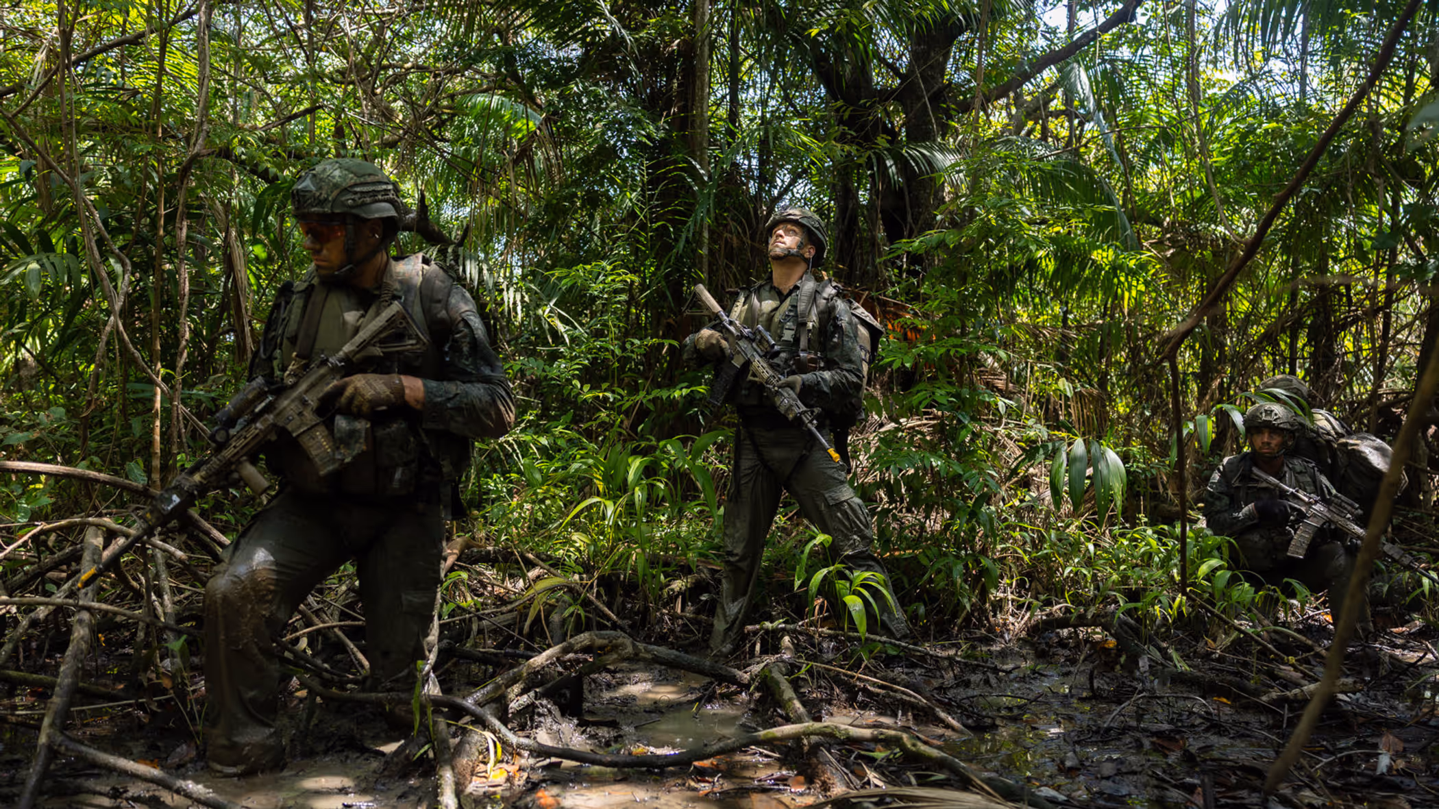2 militairen lopen op patrouille door de jungle.