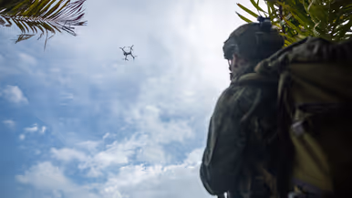 Op de 4 foto’s varen mariniers door de jungle, laat een marinier een drone op, bewaken mariniers een gevangene op het strand en stappen mariniers in een boot.