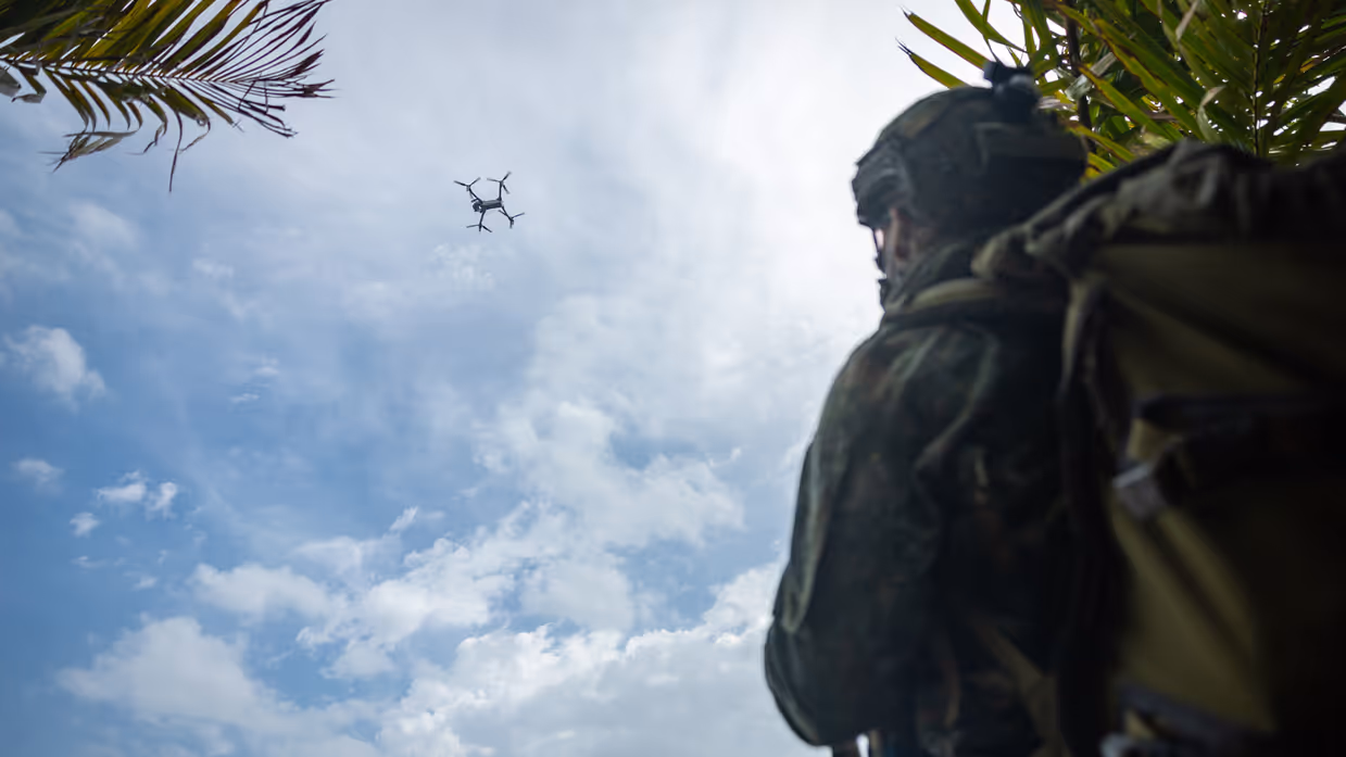 Op de 4 foto’s varen mariniers door de jungle, laat een marinier een drone op, bewaken mariniers een gevangene op het strand en stappen mariniers in een boot.