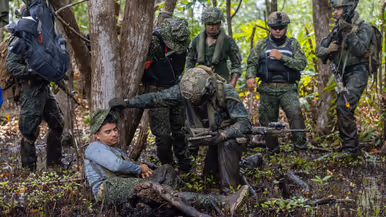Op de 4 foto’s een Colombiaanse instructeur in een boom, Colombiaanse instructeurs die zogenaamd drugs verstoppen, een Colombiaanse instructeur die een drugslab optuigt en mariniers met een zogenaamd neergeschoten kartelbaas.