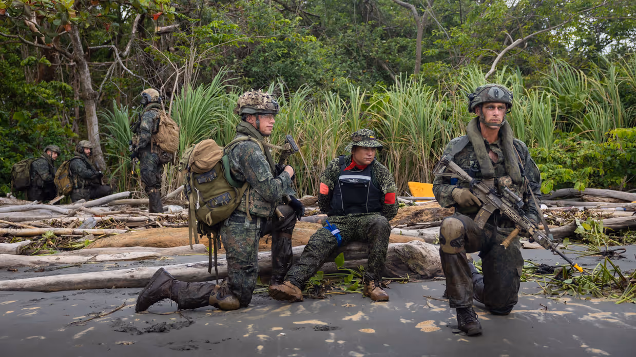 Op de 4 foto’s varen mariniers door de jungle, laat een marinier een drone op, bewaken mariniers een gevangene op het strand en stappen mariniers in een boot.