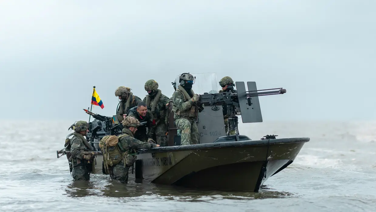 Op de 4 foto’s varen mariniers door de jungle, laat een marinier een drone op, bewaken mariniers een gevangene op het strand en stappen mariniers in een boot.