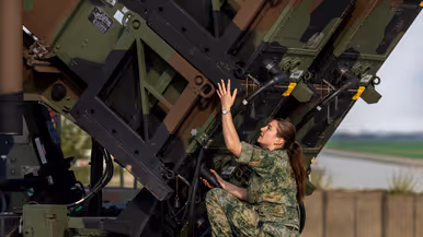 Op de linkerfoto sleutelt een militair aan een generator. Op de rechterfoto voert een militair handelingen uit aan een Patriot-lanceerinstallatie. 