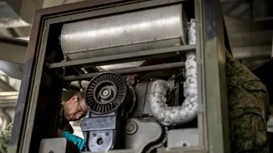 Op de linkerfoto sleutelt een militair aan een generator. Op de rechterfoto voert een militair handelingen uit aan een Patriot-lanceerinstallatie. 