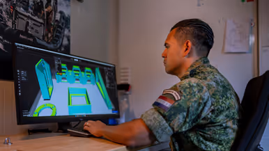 Op de linkerfoto zit Timothy achter een computer en maakt een ontwerp. Op de rechterfoto steekt hij zijn arm in een kast waarin een 3D-printer staat. 