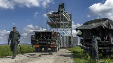 Militair sleept een brandstofslang.
