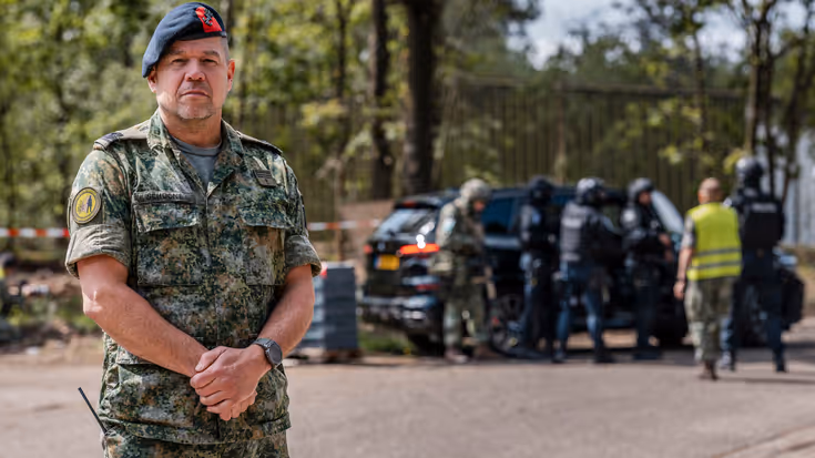 Eerste luitenant der mariniers Hans in uniform op de voorgrond met de BBTIN-eenheid op de achtergrond in actie.