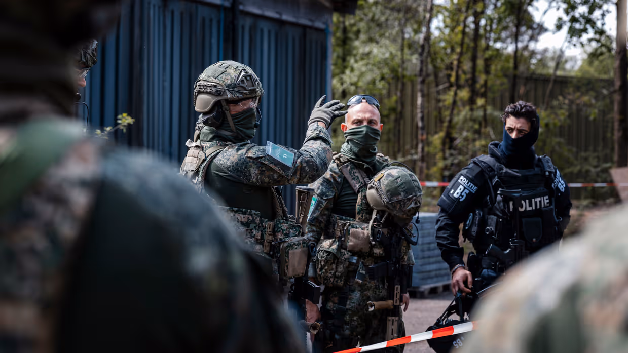 Na afloop van een scenario staan militairen en Politiemensen een bespreking te houden.