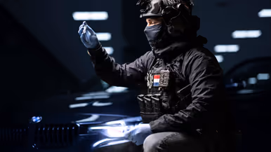 Operator in tactische uitrusting inspecteert medische apparatuur.