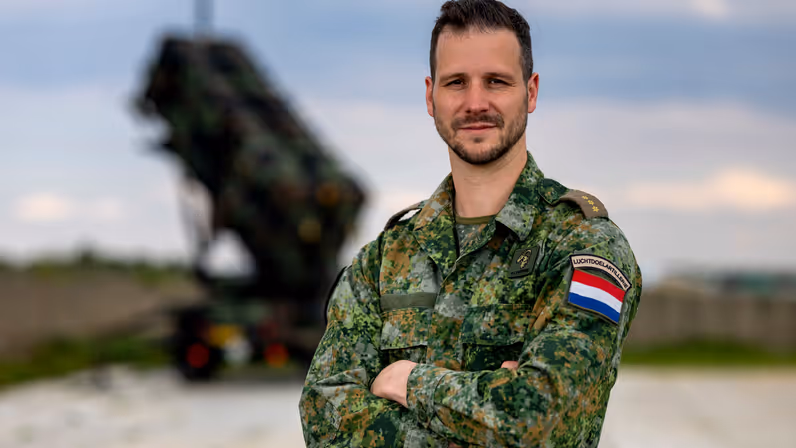 Daan met armen over elkaar, op de achtergrond staat een Patriot-lanceerinstallatie. 