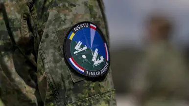 Op de linkerfoto sleutelt een militair aan een wapensysteem. Op de rechterfoto een mouwembleem van de AMDTF.
