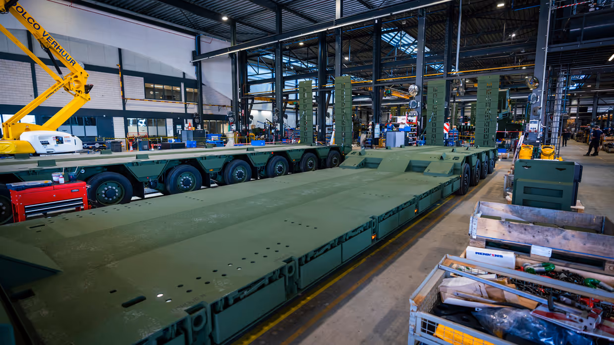 Oplegger in legergroen in servicehal fabriek.