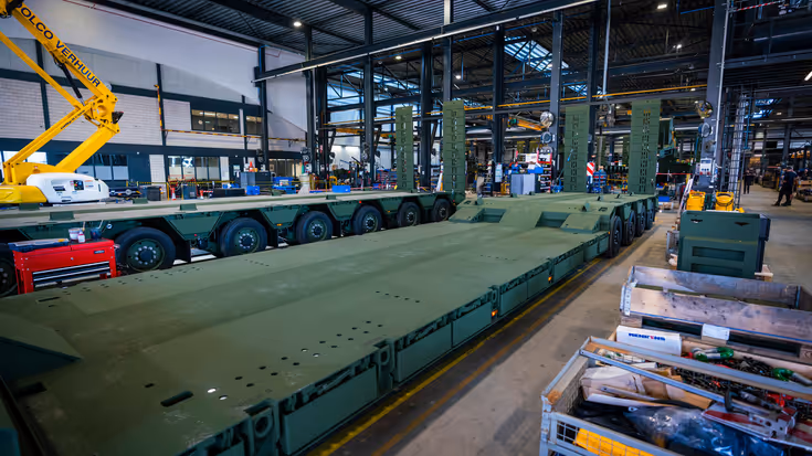 Oplegger in legergroen in servicehal fabriek.