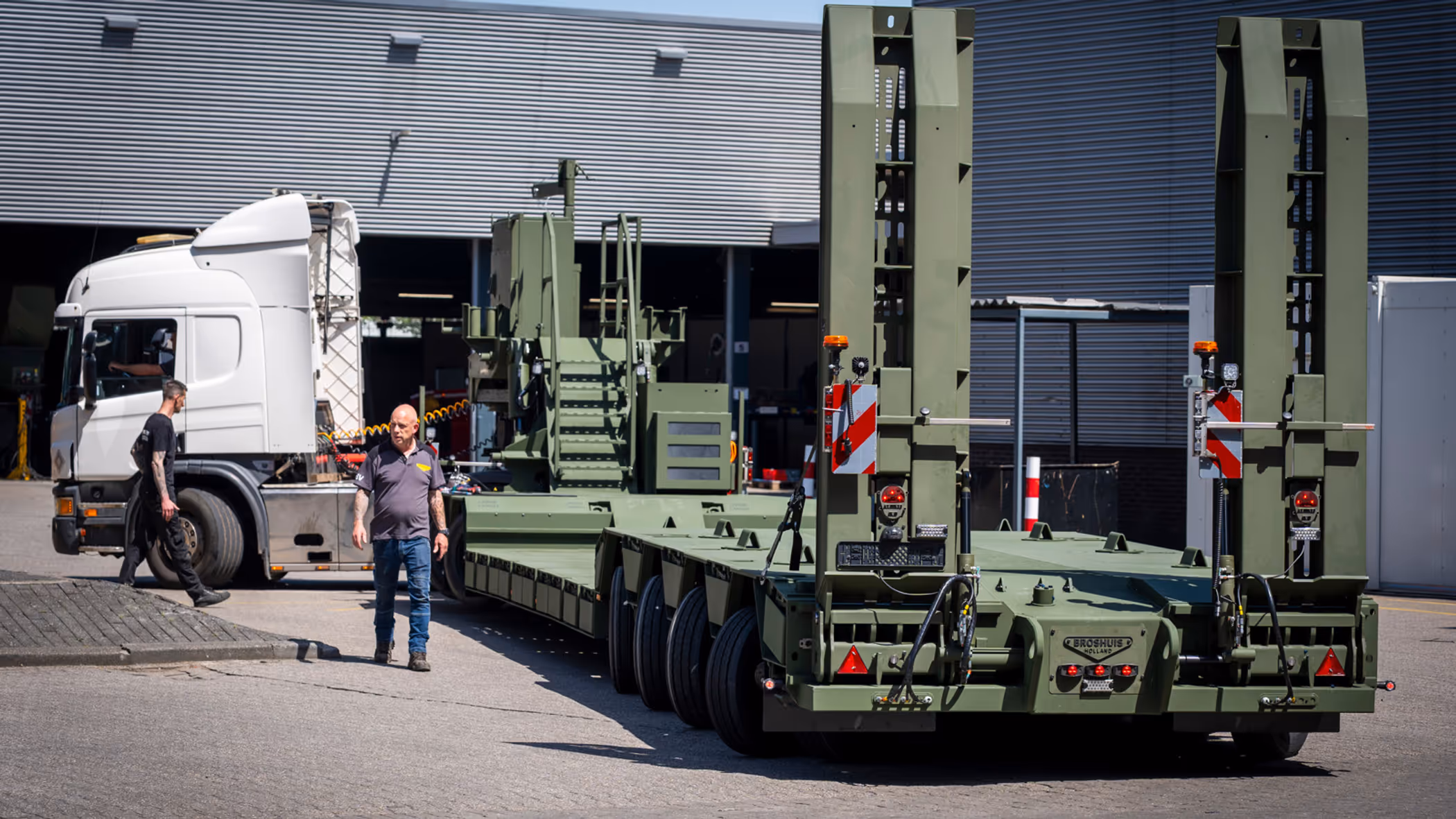 Vrachtwagen met oplegger manoeuvreert op bedrijventerrein.