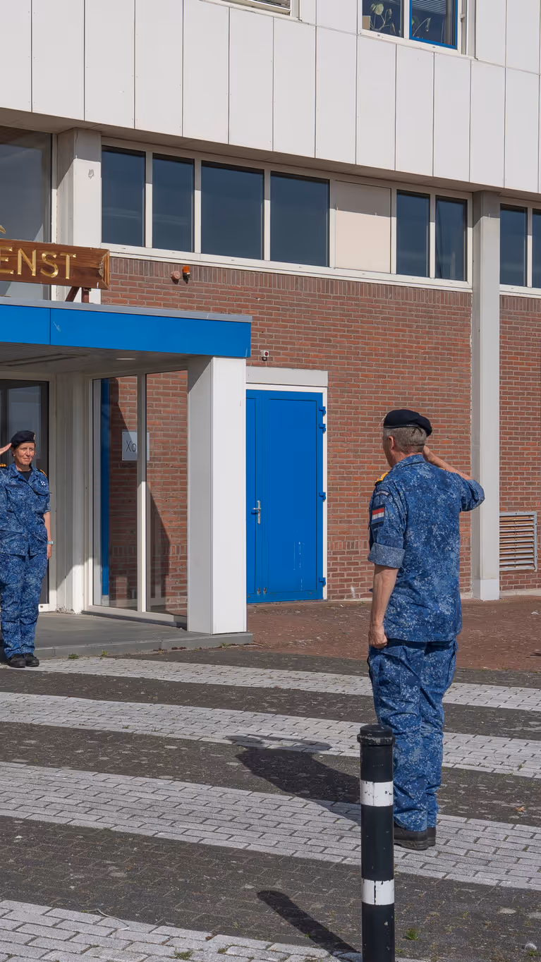  4 marinemensen staan in houding voor een hoge militair. 