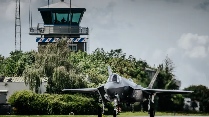 Een f35 op de startbaan met op de achtergrond de verkeerstoren.