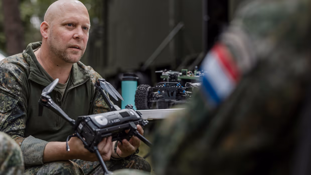 Kapitein Max van TechDevOps demonstreert tijdens oefening Fighter Lion een onbemand systeem aan collega-militairen.