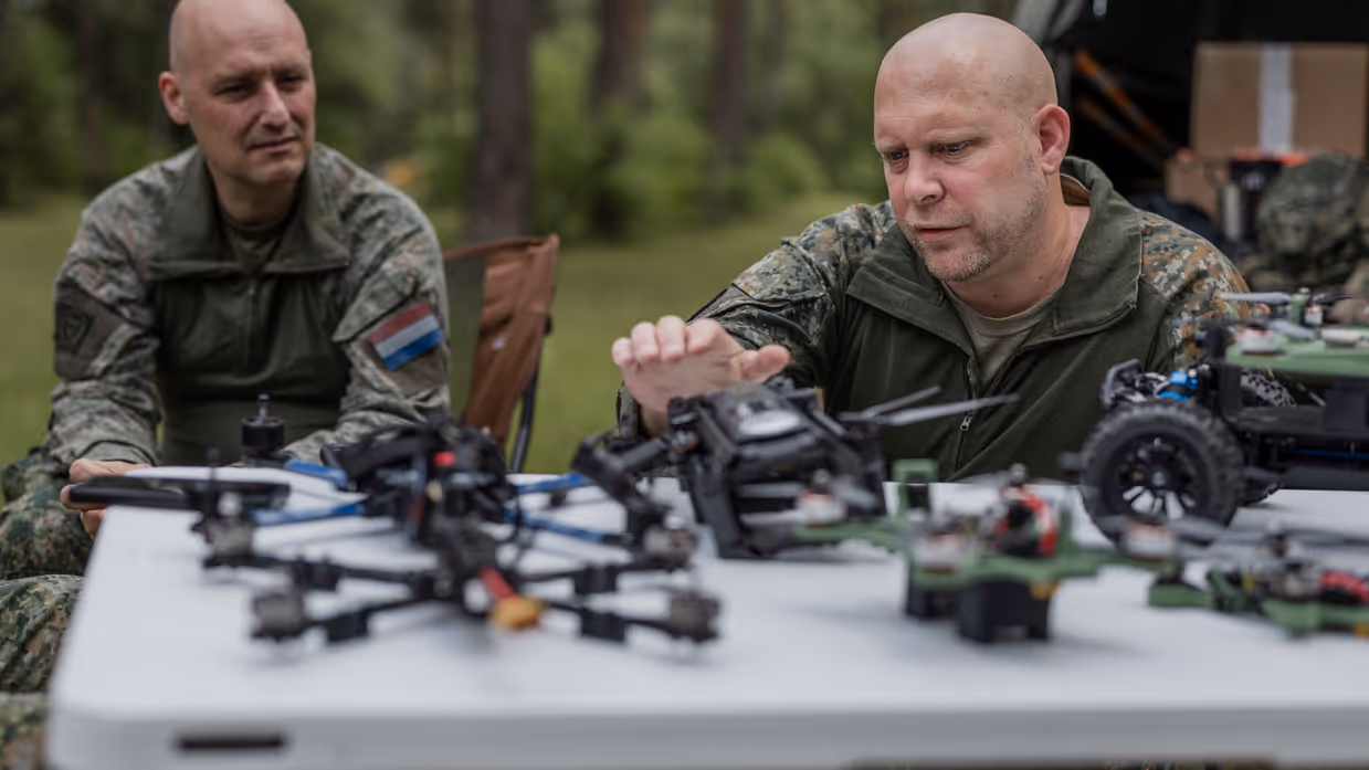 Kapitein Max en luitenant-kolonel Roeland bespreken verschillende drones en onbemande systemen tijdens oefening Fighter Lion.