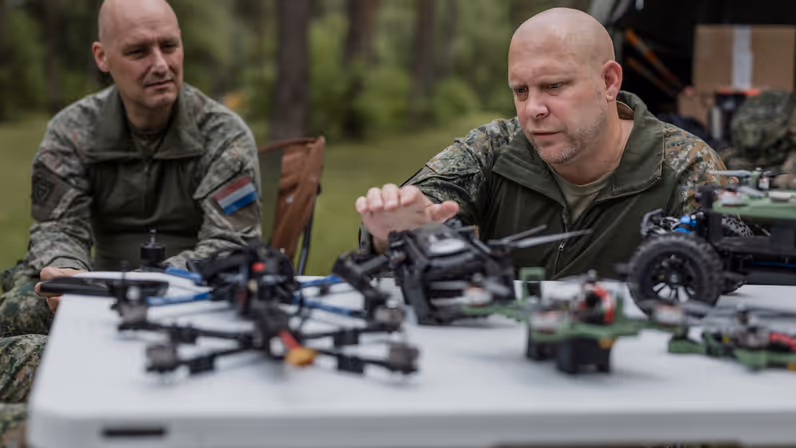 Kapitein Max en luitenant-kolonel Roeland bespreken verschillende drones en onbemande systemen tijdens oefening Fighter Lion.