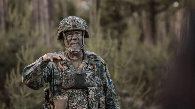 Brigadegeneraal Van Ingen geeft tijdens oefening Fighter Lion een toelichting aan militairen in het veld.