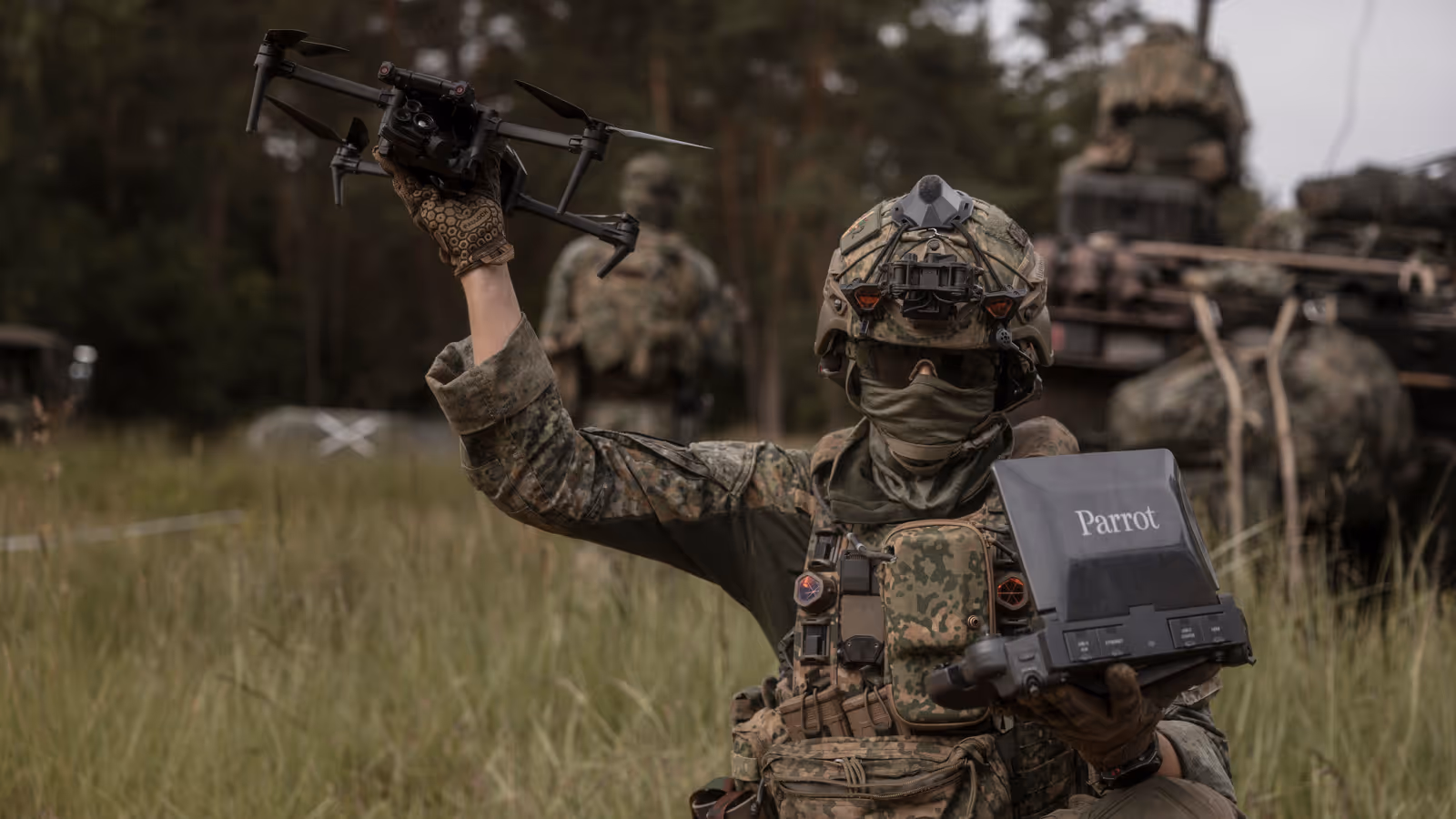Een militair tijdens oefening Fighter Lion houdt een Parrot-verkenningsdrone omhoog terwijl hij de controller vasthoudt.