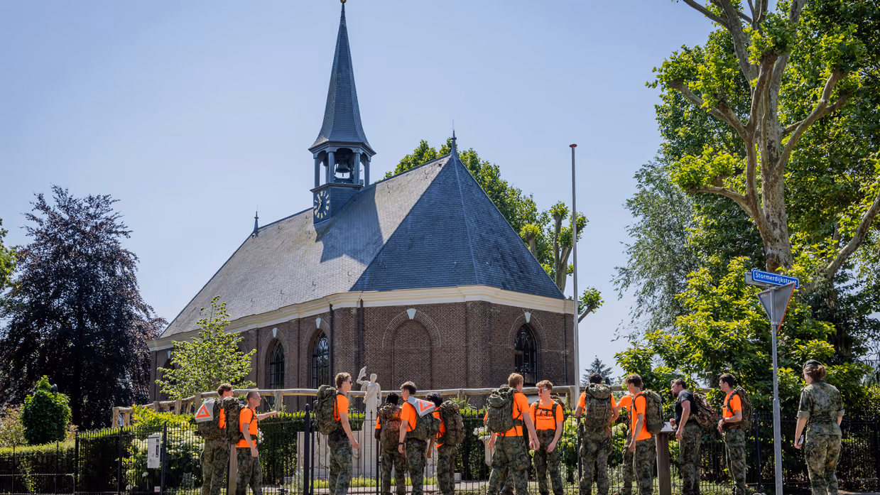 Studenten staan bij het monument te kijken