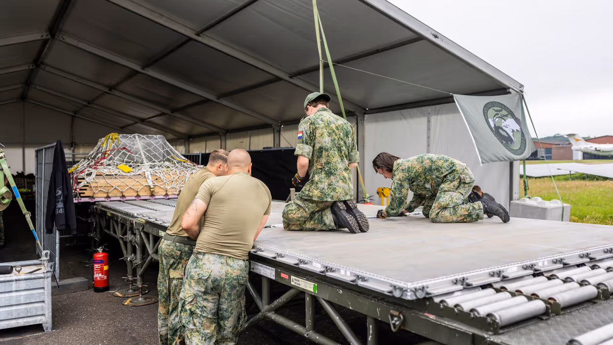 Militairen plaatsen materieel op pallets.