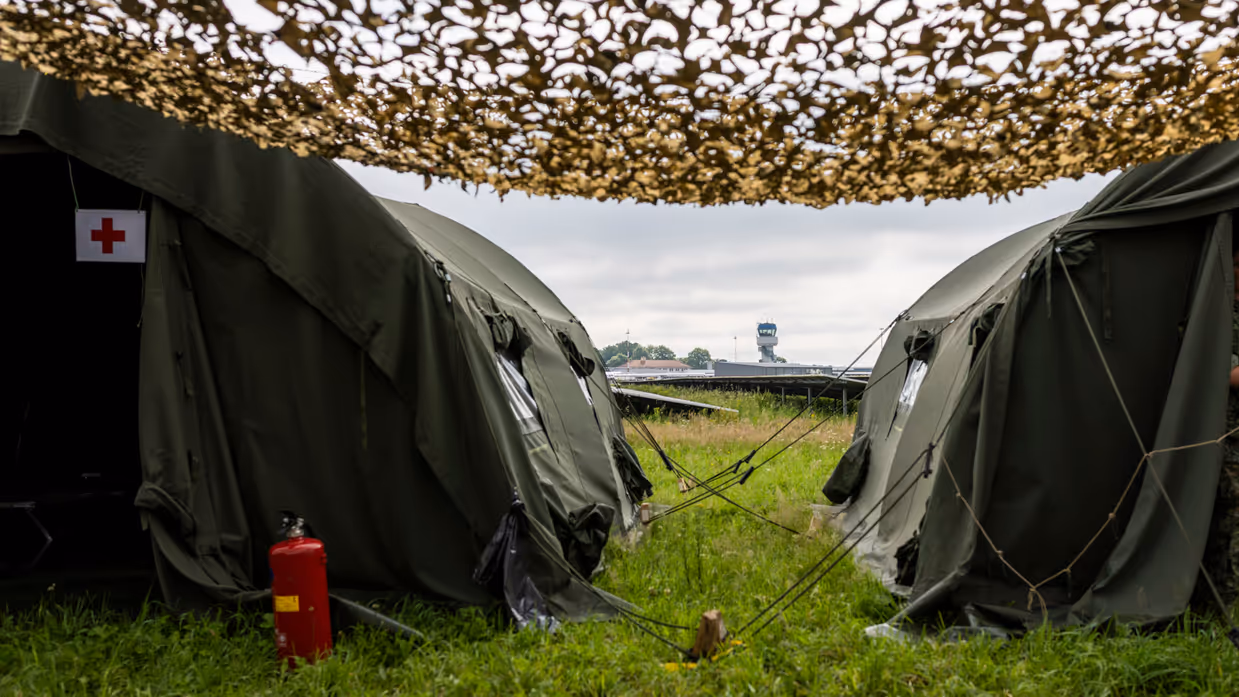  Twee groene legertenten met camouflagenetten.