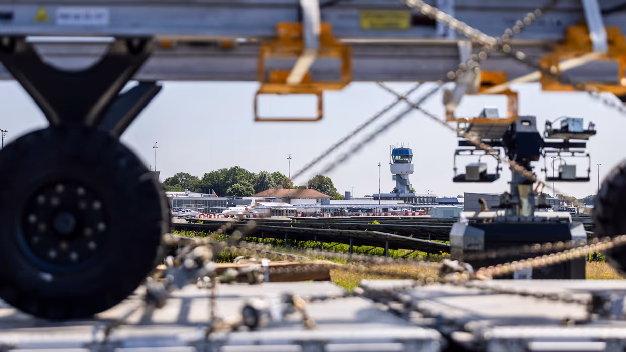 Pallet met materieel met op de achtergrond verkeerstoren vliegveld.
