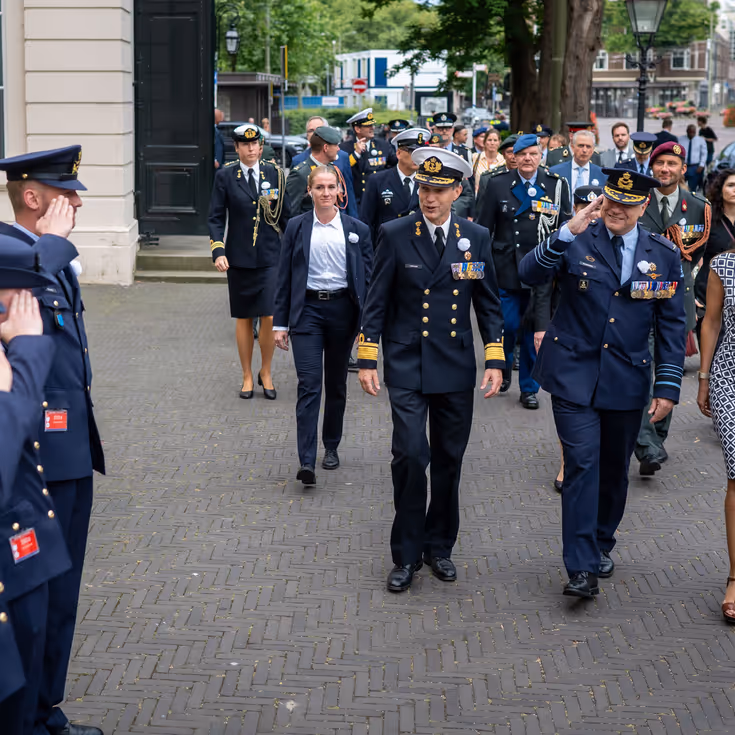 Drie luchtmachtmilitairen salueren naar de CDS en minister van Defensie als zij aankomen bij de Koninklijke Schouwburg in Den Haag 