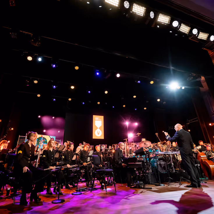 Het volledige Orkest Koninklijke Luchtmacht op het podium van de Koninklijke Schouwburg.