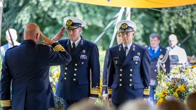 Te midden van publiek en bloemen salueert Boots naar een kolonel der mariniers. Naast hem staat Van de Sande.