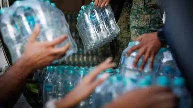 Treetjes met flessen water worden doorgegeven.