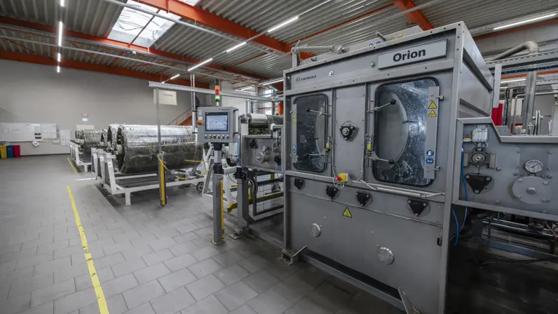 Water klotst op en neer in industriële wasmachine voor stoffen.