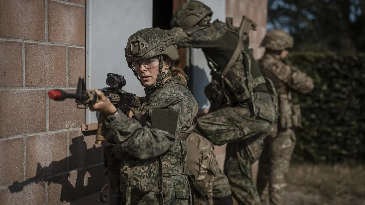 Studentmilitairen staan op het punt een gebouw te betreden.