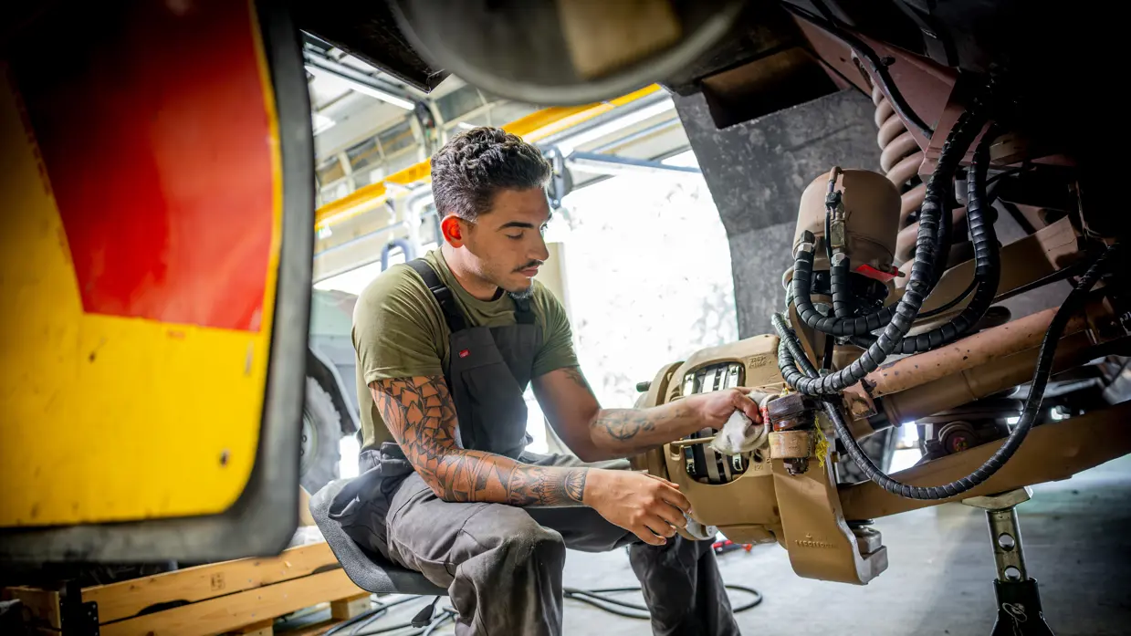Jayden bezig in de wielkast van een Bushmaster. 