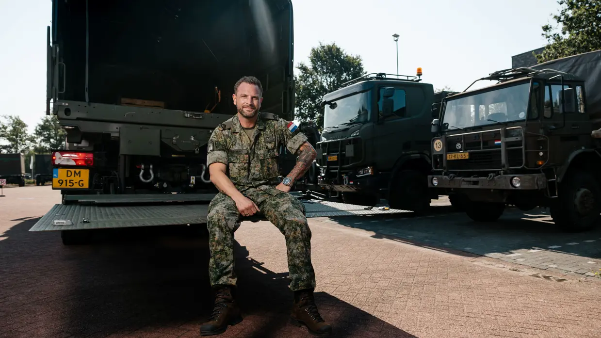Mike zit op de laadklep van een Scania.
