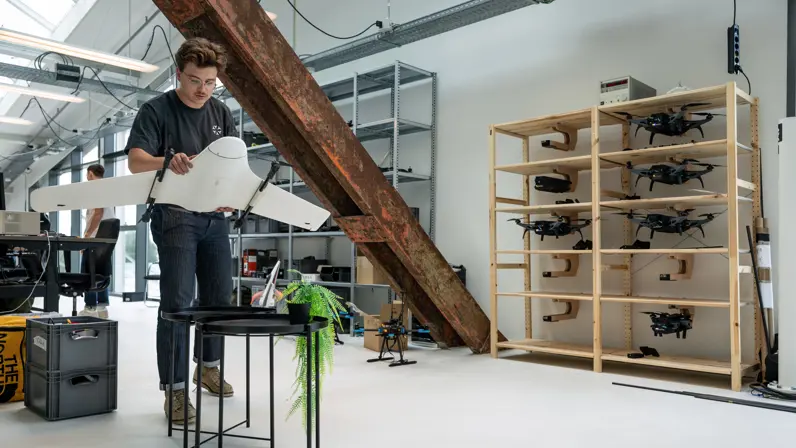 Een medewerker van Intelic loopt met een drone door een pand.