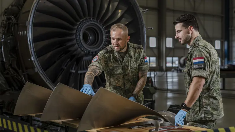 Roy van der Mark begeleidt een collega tijdens werkzaamheden aan een onderdeel van een A330 MRTT in een onderhoudshangar.