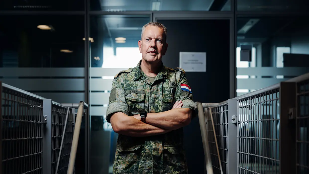 Portretfoto van brigadegeneraal Kees Koek in gevechtstenue, met de armen over elkaar.