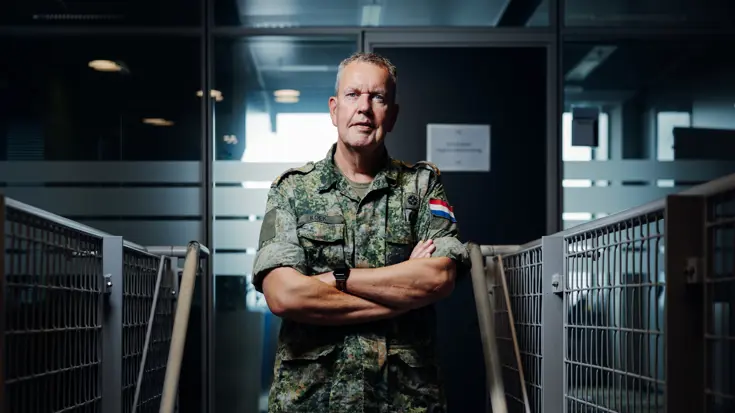 Portretfoto van brigadegeneraal Kees Koek in gevechtstenue, met de armen over elkaar.