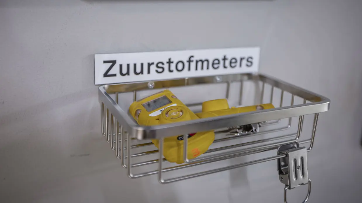 gele zuurstofmeters in een bakje aan de muur