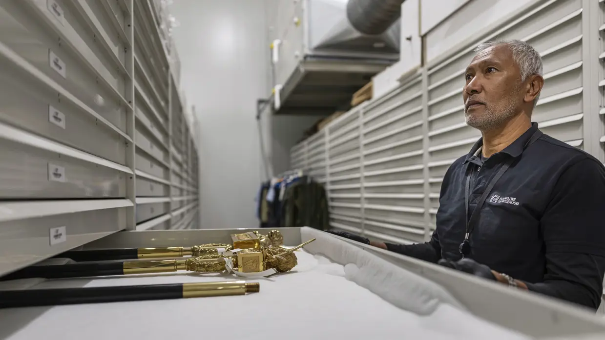 Bob Beelt trekt een lade open waarin gouden elementen voor een vaandel liggen.
